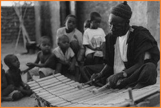 Grandfather Wamian Kon� plays the bala xylophone for his grandchildren and friends.