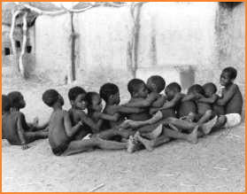 Village boys and girls play a dance-game.